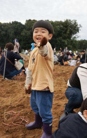 掘り上げたからいもを嬉しそうに差し出す男の子