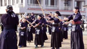 剣道衣を身にまとい一生懸命素振りをする児童