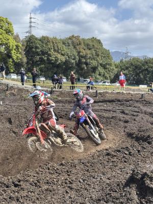砂埃が舞う中白熱したバイクレースが行われている写真