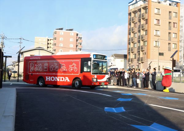 バスを見送る関係者