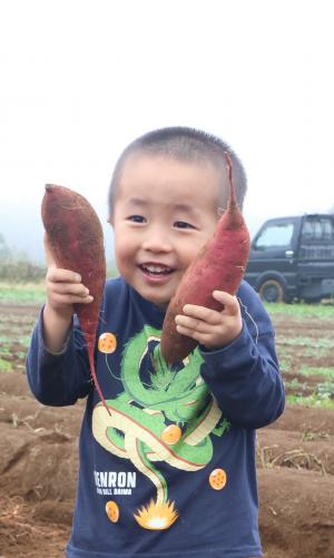 おいもを持ってポーズを取る子ども