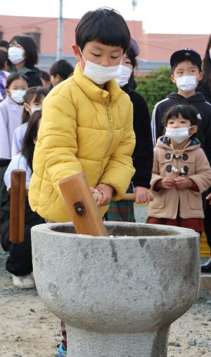 真剣な表情で餅つきをする子ども