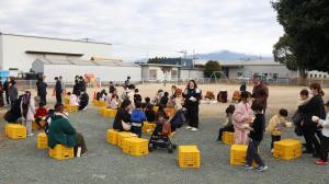 椅子に座ってお餅を食べる参加者